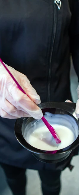 Close-up of a hairdresser preparing hair dye in a bowl. Close-up of a hairdresser preparing hair dye in a bowl.